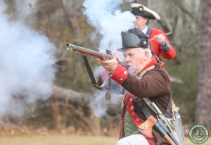 Jagger kneels with drummer behind