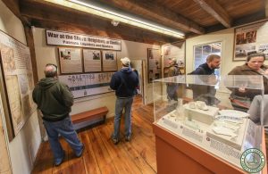 Back room at Cedar Bridge with people enjoying interpretative panels