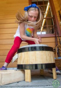 young girl turns grist mill