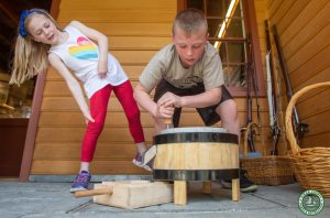Two children use grist mill quern