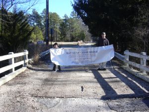 Mike Spiecker and James hold banner on bridge